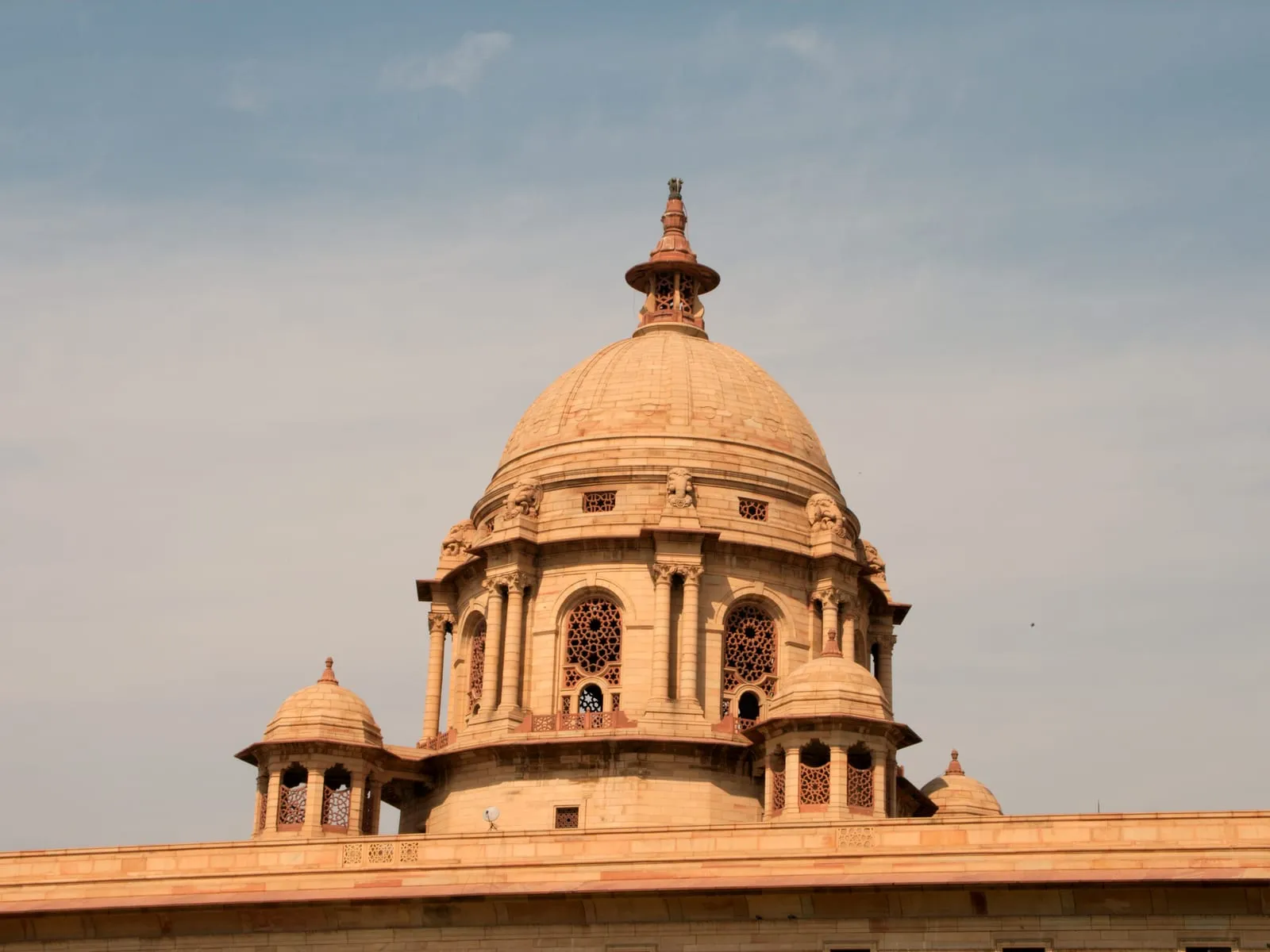 The sandstone dome of a government secretariat building against a clear sky.