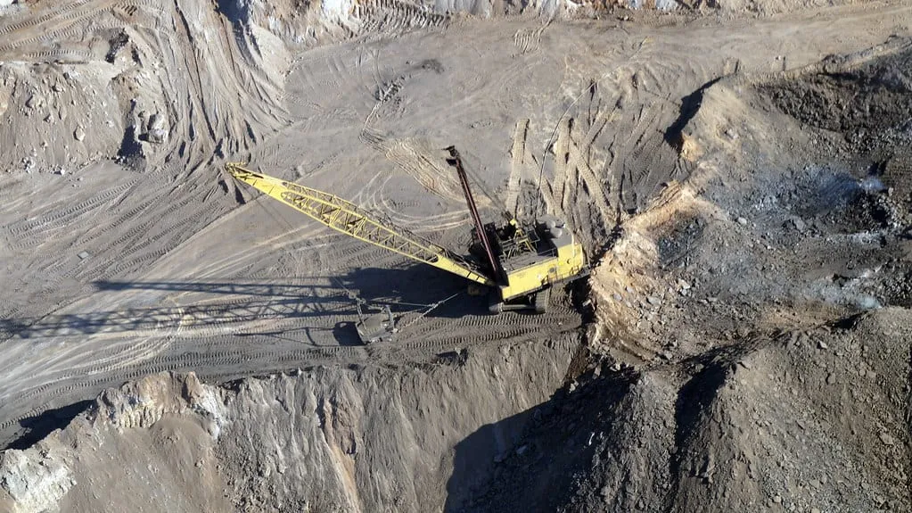 A dragline excavator working a bench in a large open-cast pit.