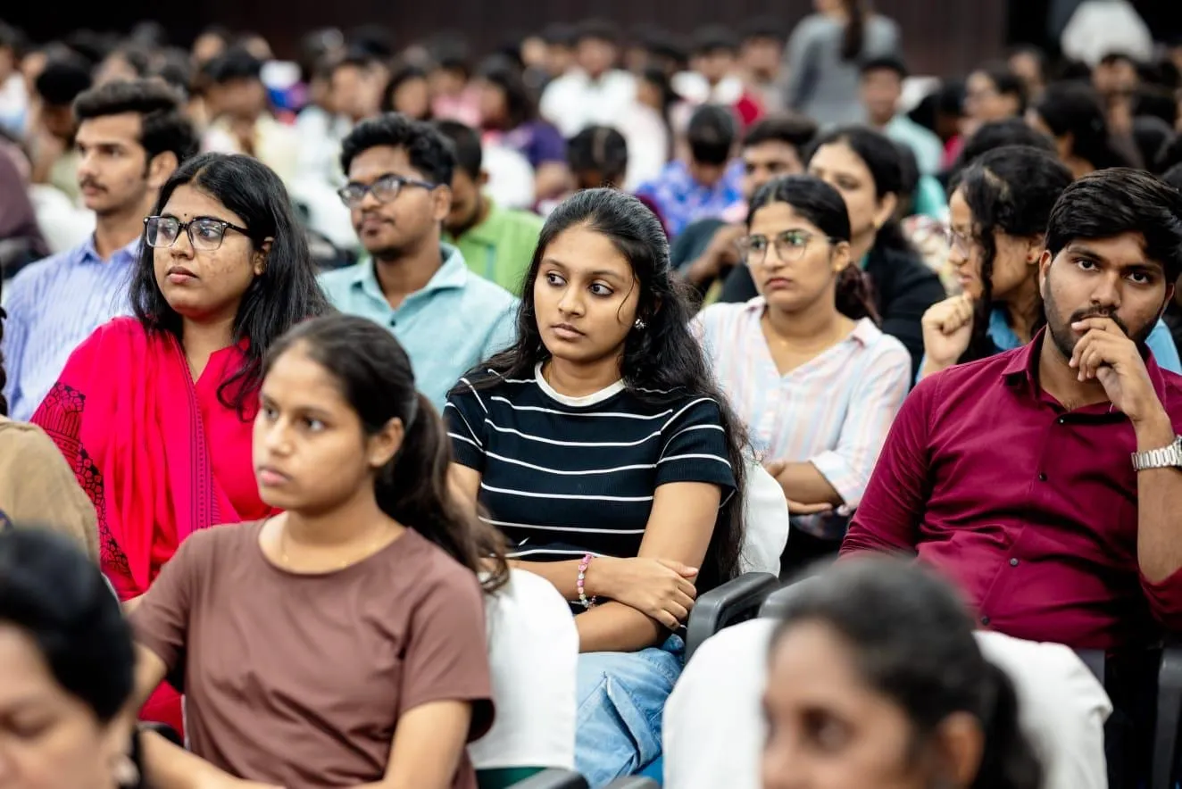 Students seated closely together, listening to a session at the conclave.